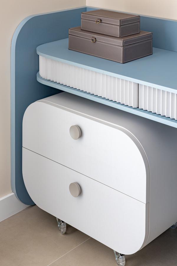 Detalhe de bancada azul com gaveteiro branco de cantos arredondados